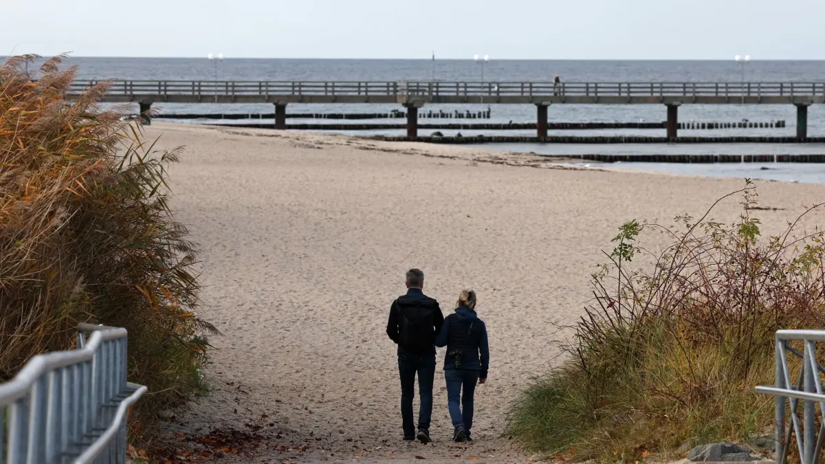 Ruhiges Herbstwetter im Norden: 03.11.2025, Mecklenburg-Vorpommern, Kühlungsborn: Spaziergänger nutzen das ruhige Herbstwetter für einen Ausflug an den Ostseestrand. Foto: Bernd Wüstneck/dpa +++ dpa-Bildfunk +++