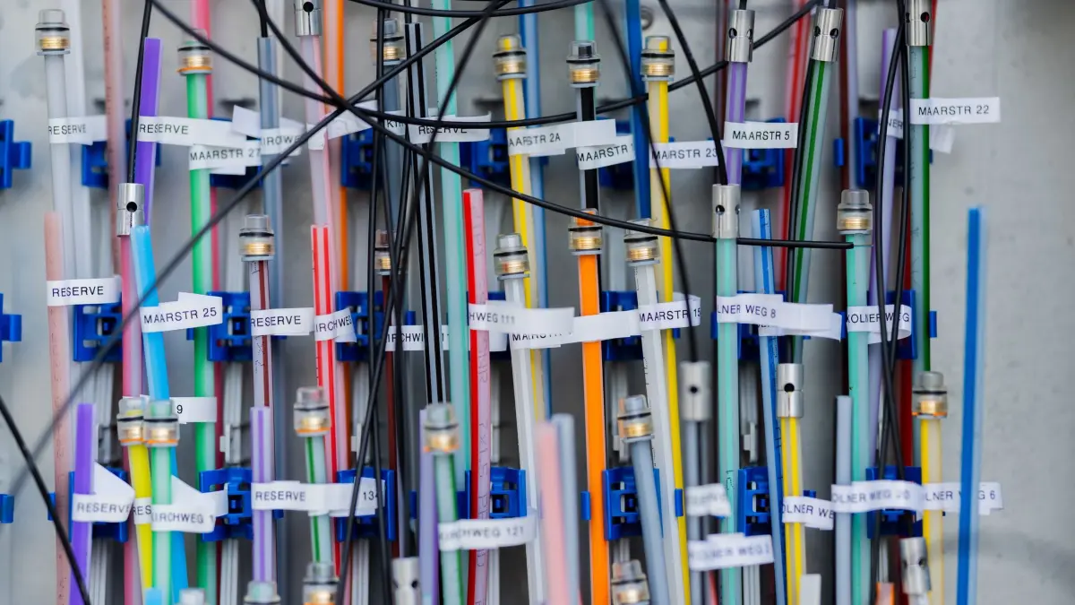Glasfaser: PRODUKTION - 06.11.2025, Nordrhein-Westfalen, Köln: Glasfaserleitungen liegen in einem Verteilerkasten. Foto: Rolf Vennenbernd/dpa +++ dpa-Bildfunk +++