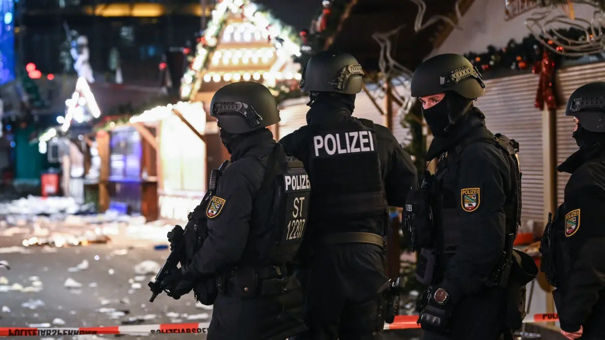 Schwer bewaffnete Polizisten auf dem verwüsteten Weihnachtsmarkt. Kurz vor Weihnachten war ein 50-Jähriger aus Saudi-Arabien mit einem Auto über den Magdeburger Weihnachtsmarkt gerast. (zu dpa: «Magdeburg-Anschlag - Behörden weisen Schuld von sich») 519994580 +++ dpa-Bildfunk +++
