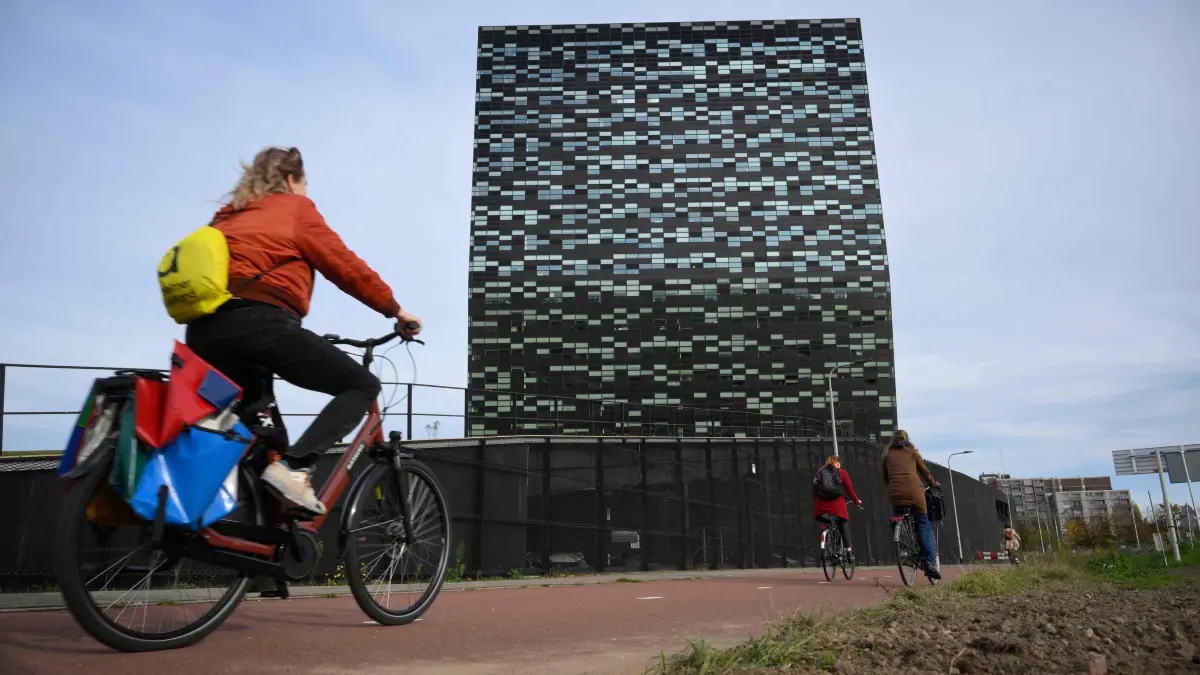 A woman rides past Nexperia headquarters in Nijmegen on November 6, 2025. China said on November 1, 2025 it will exempt some Nexperia chips from an export ban that was imposed over a row with Dutch officials and has alarmed European businesses. (Photo by JOHN THYS / AFP)