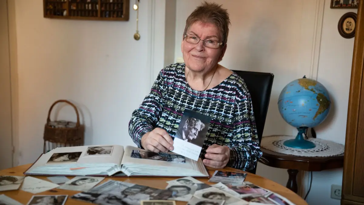 Traudel Luithardt in ihrem Wohnzimmer, vor ihr einige der Autogramme aus ihrer Sammlung, in den Händen hält sie ihr liebstes Autogramm von Albert Schweitzer.