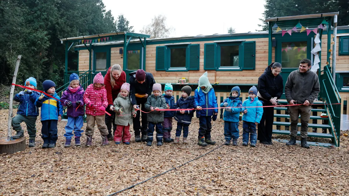 Der Dettinger Naturkindergarten und die neue Bauwagen-Unterkunft sind offiziell eröffnet: Die Kleinen haben mit dem Erzieher-Team das rote Band durchschnitten.