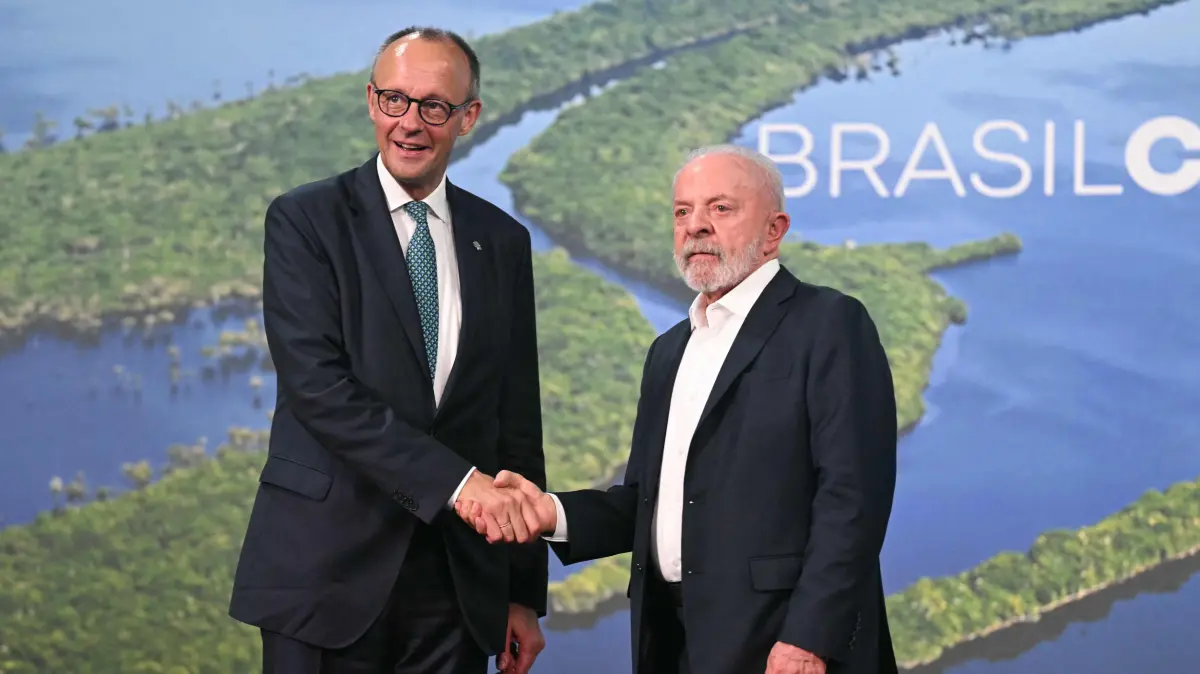 Germany's Chancellor Friedrich Merz (L) and Brazil's President Luiz Inacio Lula da Silva shake hands after a bilateral meeting within the framework of the COP30 UN climate conference in Belem, Para State, Brazil on November 7, 2025. (Photo by Mauro PIMENTEL / AFP)