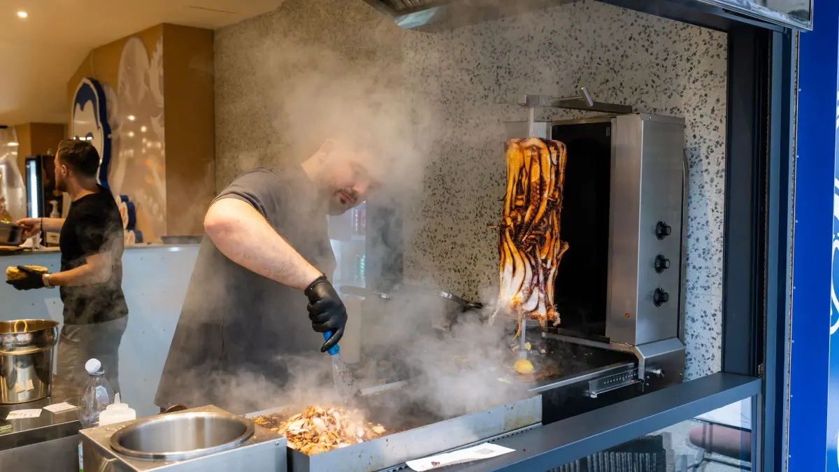Calamari-Kebab: PRODUKTION - 07.11.2025, Baden-Württemberg, Karlsruhe: Ein Mitarbeiter bereitet im Restaurant «Pescobar» das Fleisch für einen Calamari-Kebab zu. Nach der ersten Filiale in London hat ein rumänischer Meeresfrüchte-Anbieter nun seine zweite Filiale mit Calamari-Kebab in Karlsruhe eröffnet. (zu dpa: «Neuer Döner-Hype? Tentakel am Spieß sorgt für Wirbel») Foto: Philipp von Ditfurth/dpa +++ dpa-Bildfunk +++