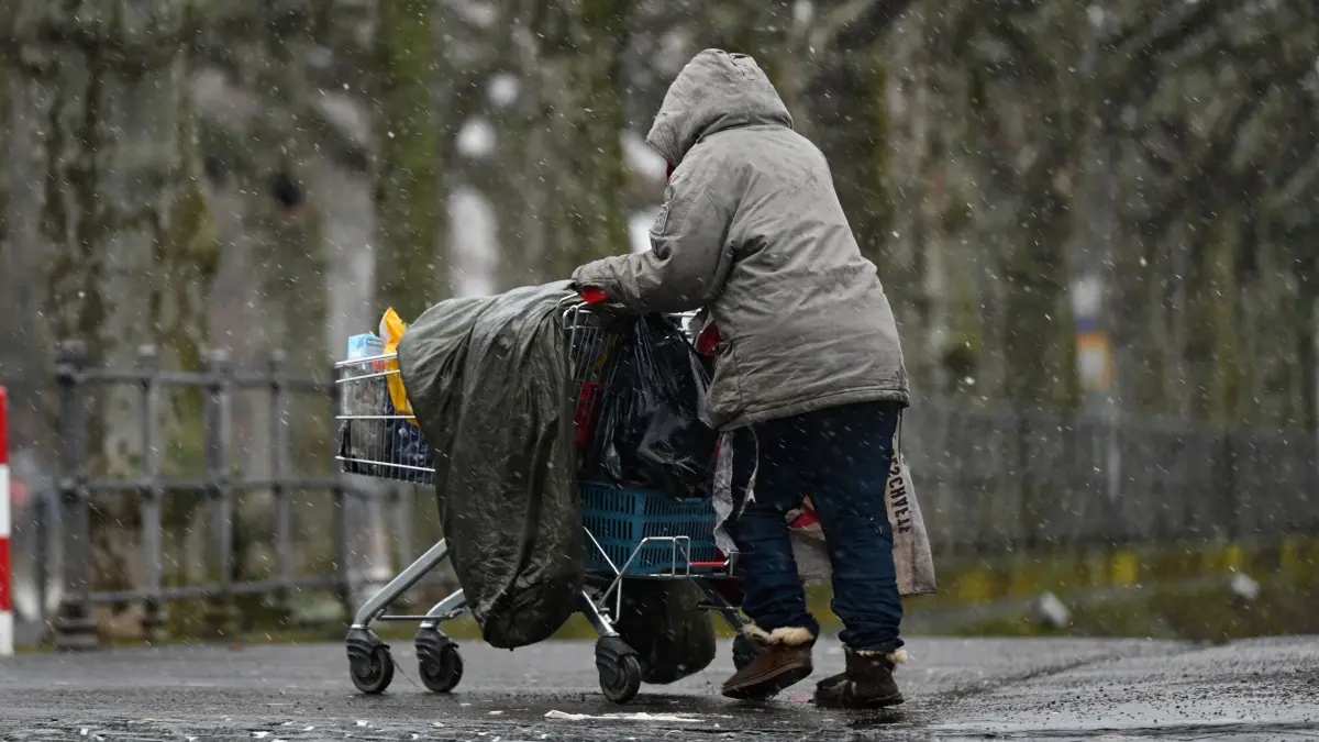 Angebote für Obdachlose im Winter: ARCHIV - 27.01.2021, Hessen, Frankfurt/Main: Eine obdachlose Frau schiebt ihr Hab und Gut in einem Einkaufswagen. (zu dpa: «Kommunen sehen sich für Winter-Obdachlosenhilfe gut gerüstet») Foto: Arne Dedert/dpa +++ dpa-Bildfunk +++