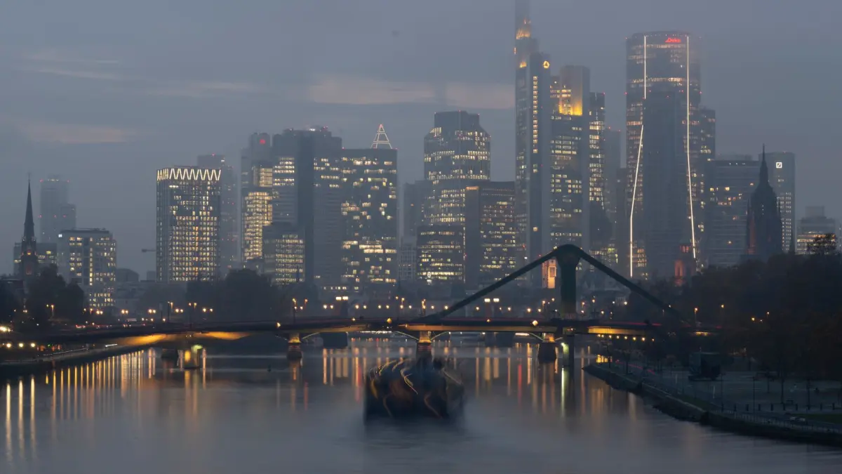 Bankenskyline im Nebel: 10.11.2025, Hessen, Frankfurt/Main: Aufziehender Nebel liegt im letzten Licht des Tages über der Bankenskyline von Frankfurt, während ein Schiff über den Main fährt. Foto: Boris Roessler/dpa +++ dpa-Bildfunk +++