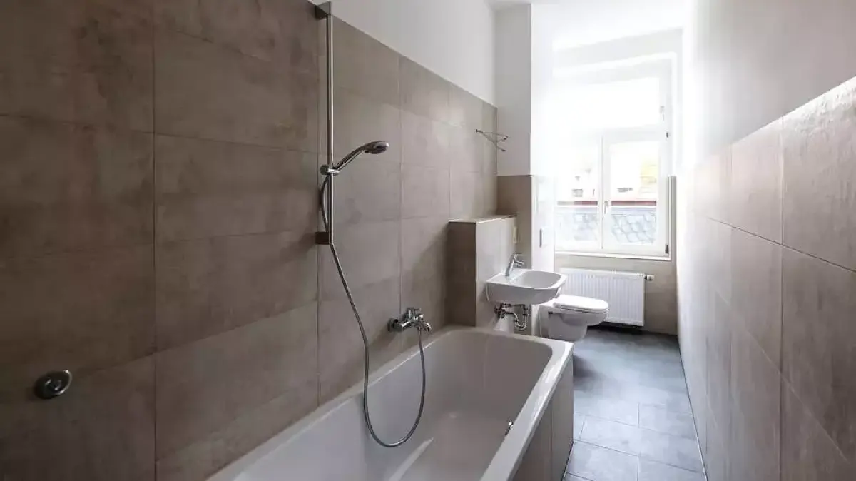 Selbst das Bad ist neu, doch die Aussicht aus dem Badezimmerfenster passt nicht zur tatsächlichen Umgebung. Wissen, was so konkret fast nur Anwohner haben.