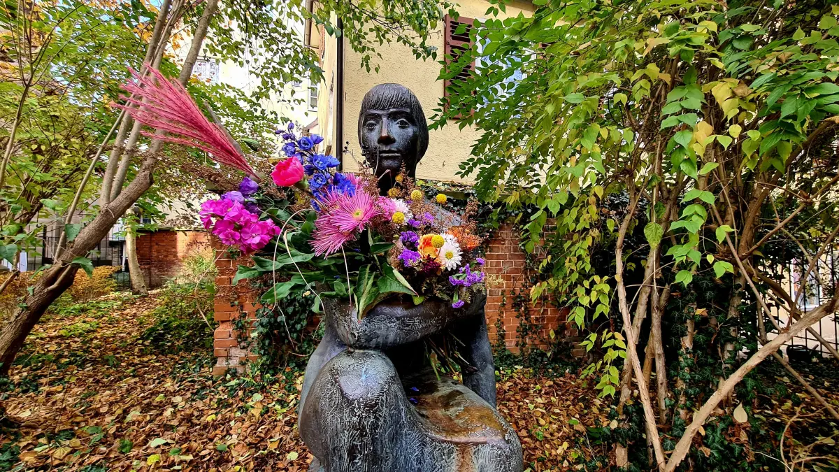 Sitzende Frau Johanneskirche Tübingen Blumen
