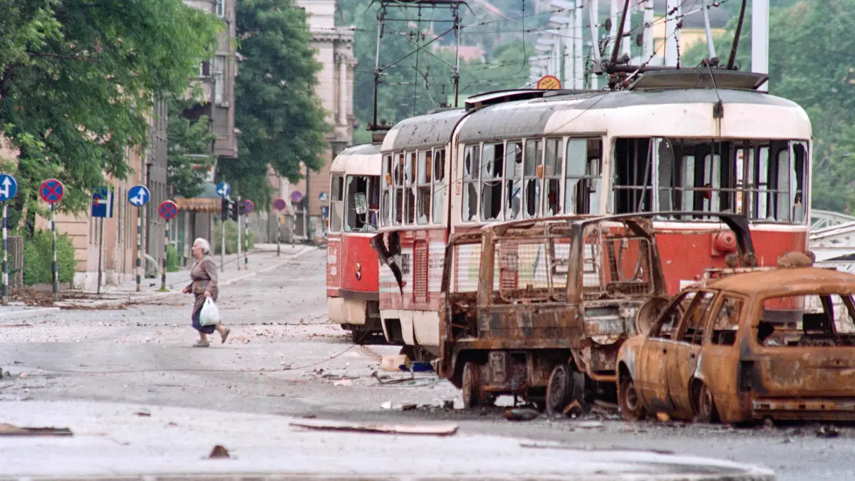(FILES) Picture taken on June 25, 1992 at Sarajevo showing an elderly resident taking advantage of the break in firing by going out for supplies. This central area of the town is reputed to be the most dangerous area because of sniper fire. Milan's prosecutor office has opened an investigation into "weekend snipers," many of them Italians, who during the siege of Sarajevo in the early 1990s allegedly paid the Serbian army to shoot civilians, according to the Italian press and the former mayor of Sarajevo. These "war tourists," mostly wealthy, gun-loving, far-right sympathizers, gathered in Trieste, northern Italy, before being taken to the hills surrounding Sarajevo, according to La Repubblica newspaper. (Photo by Christophe SIMON / AFP)