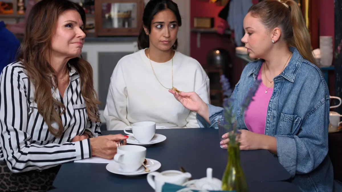 Esma (Özge Delioglan, M.) wird von Britta (Tabea Heynig, l.) ermutigt, ihr Familienerbstück zu verpfänden. Rechts Ronja (Theresa Traser)