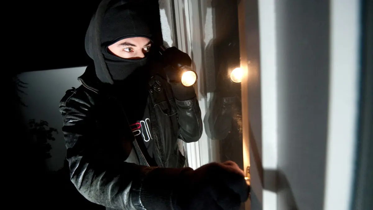 ARCHIV - ILLUSTRATION - Ein vermummter Einbrecher mit Taschenlampe schaut durch ein Fenster in eine Wohnung, aufgenommen am 25.11.2011. In Deutschland findet alle zwei Minuten ein Einbruch statt. Um solchen Taten während des Urlaubs vorzubeugen, hilft vor allem eins: Anwesenheit vortäuschen. Foto: Andreas Gebert/dpa (zu lni "Mehr Einbrecher im Herbst auf Beutezug" vom 26.08.2014) +++(c) dpa - Bildfunk+++