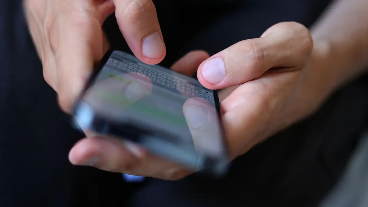 Mann tippt auf einem Smartphone eine WhatsApp Nachricht: ILLUSTRATION - Die Drittanbieter-Chats bei Whatsapp sind zunächst nur mit den Messengern Birdychat und Haiket möglich. (zu dpa: «Whatsapp: Chats mit anderen Messengern ab sofort möglich») Foto: Karl-Josef Hildenbrand/dpa/dpa-tmn - Honorarfrei nur für Bezieher des dpa-Themendienstes +++ dpa-Themendienst +++