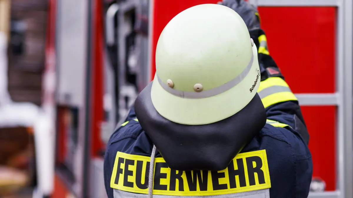 Feuerwehr - Symbolbild: ARCHIV - 05.11.2022, Rheinland-Pfalz, Staufen: Ein Feuerwehrmann holt während einer Einsatzübung einer Freiwilligen Feuerwehr eine Leiter vom Dach eines Einsatzfahrzeugs. (zu dpa: «Erdgeschosswohnung in Flammen - Mann vermisst») Foto: Philipp von Ditfurth/dpa +++ dpa-Bildfunk +++