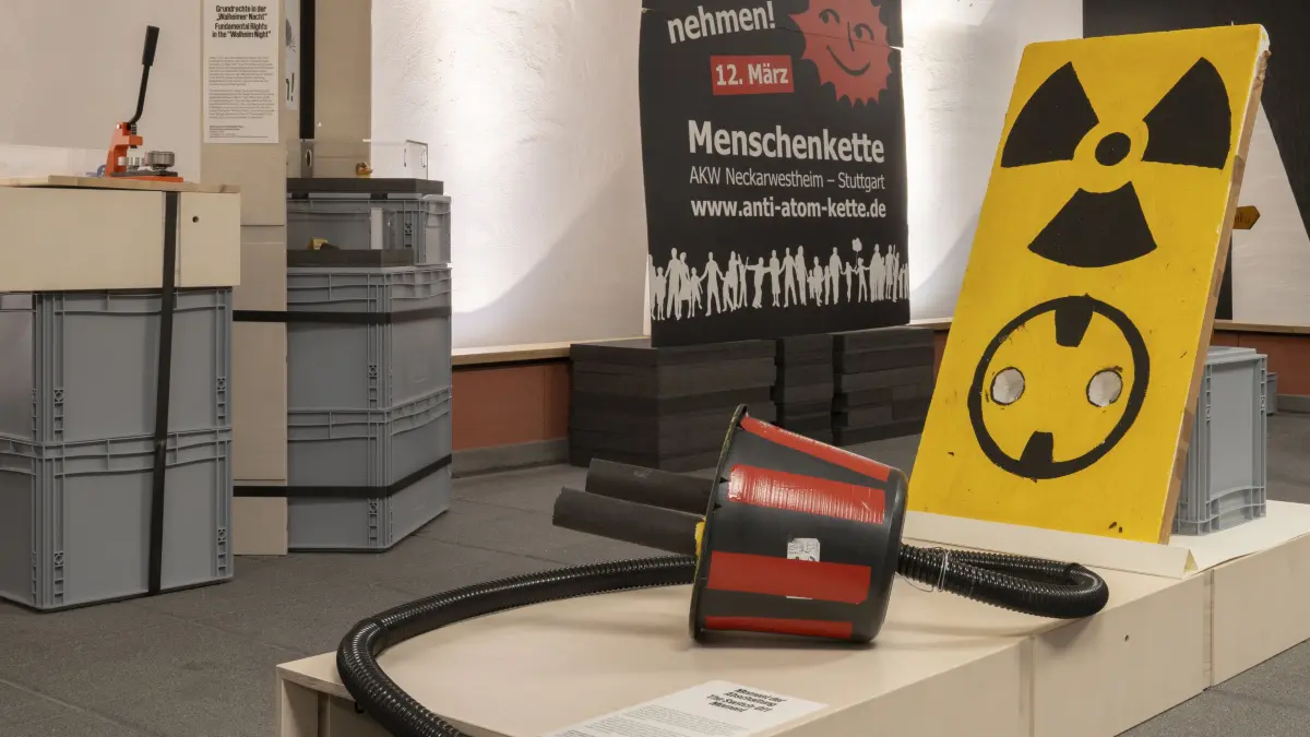 Ein gebastelter Stecker aus Kunststoffen, der in der Sammlungswerkstatt zu betrachten ist. Am 15. April 2023 feierte die Anti-AKW-Bewegung mit einem Abschaltfest vor dem AKW Neckarwestheim die Stilllegung der letzten drei Atomkraftwerke in Deutschland. Auf der Bühne wurde dem Atomstrom symbolisch dieser Stecker gezogen und von mehreren Personen in selbst gebastelte Solarmodule umgesteckt.