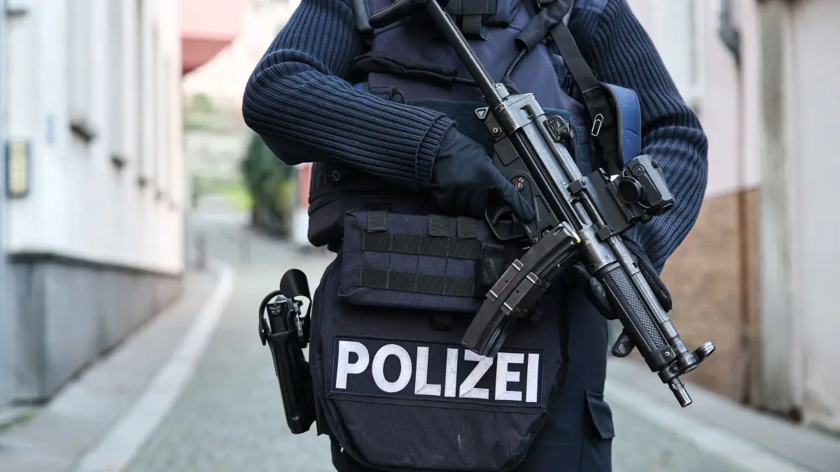 Amokalarm in Mainz: 21.11.2025, Rheinland-Pfalz, Mainz: Eine Polizistin steht in Schutzweste und mit einer MP5 Maschinenpistole bewaffnet nahe der Schule. Am Morgen gegen 07:40 Uhr kam es zur Amokalarm Auslösung am Williges Gymnasium in Mainz. Foto: Hannes P Albert/dpa +++ dpa-Bildfunk +++