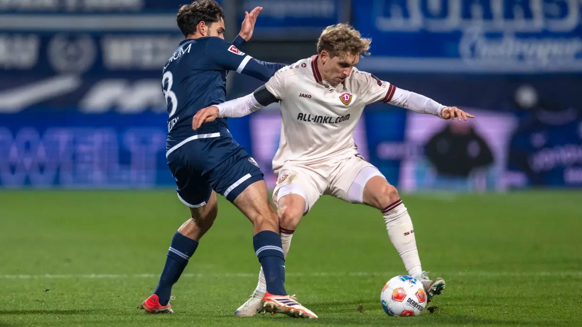 VfL Bochum - Dynamo Dresden: 21.11.2025, Nordrhein-Westfalen, Bochum: Fußball: 2. Bundesliga, VfL Bochum - Dynamo Dresden, 13. Spieltag, Vonovia Ruhrstadion: Kjell Wätjen (VfL Bochum) (l) und Luca Herrmann (Dynamo Dresden) kämpfen um den Ball. Foto: David Inderlied/dpa - WICHTIGER HINWEIS: Gemäß den Vorgaben der DFL Deutsche Fußball Liga bzw. des DFB Deutscher Fußball-Bund ist es untersagt, in dem Stadion und/oder vom Spiel angefertigte Fotoaufnahmen in Form von Sequenzbildern und/oder videoähnlichen Fotostrecken zu verwerten bzw. verwerten zu lassen. +++ dpa-Bildfunk +++