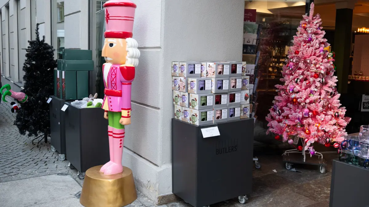 Weihnachten, alternativer Weihnachtsschmuck, pinker Weihnachtsbaum, pinker Nussknacker und im Weihnachtsbaum steckende Wichtel (hinten links) vor dem Eingang von Butlers.