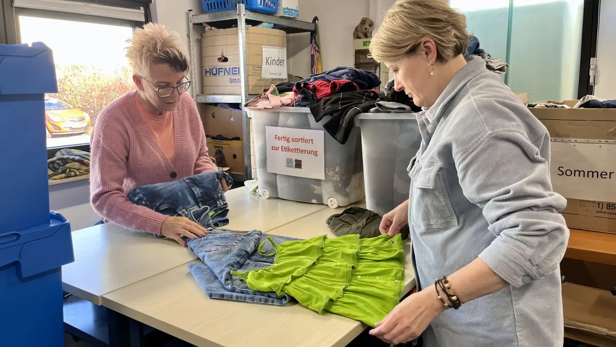 Renate Meinlschmidt (links) und Maryna Osauliuk prüfen die Teile aus den Altkleidersäcken in einem Spendenlager außerhalb von Schwäbisch Hall. Nur ein minimaler Teil der Kleidungsstücke eignet sich für den Weiterverkauf.