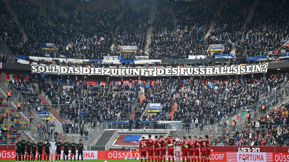 Fortuna Düsseldorf - 1. FC Magdeburg: 22.11.2025, Nordrhein-Westfalen, Düsseldorf: Fußball: 2. Bundesliga, Fortuna Düsseldorf - 1. FC Magdeburg, 13. Spieltag, Merkur Spiel-Arena. Protest «Soll das die Zukunft des Fußballs sein?» der 1. FC Magdeburg Fans. Foto: Anke Waelischmiller/dpa - WICHTIGER HINWEIS: Gemäß den Vorgaben der DFL Deutsche Fußball Liga bzw. des DFB Deutscher Fußball-Bund ist es untersagt, in dem Stadion und/oder vom Spiel angefertigte Fotoaufnahmen in Form von Sequenzbildern und/oder videoähnlichen Fotostrecken zu verwerten bzw. verwerten zu lassen. +++ dpa-Bildfunk +++