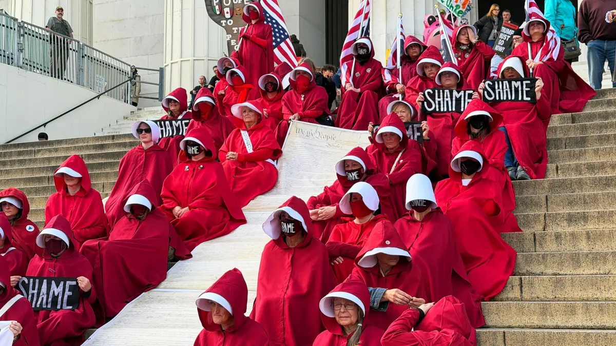 Protest gegen US-Präsident Trump in Washington: 22.11.2025, USA, Washington: Demonstrantinnen tragen Kostüme aus der US-amerikanischen Drama-Fernsehserie «The Handmaid's Tale - Der Report der Magd» bei einem Protest gegen die Politik von US-Präsident Trump vor dem Lincoln Memorial. Foto: Thomas Müller/dpa +++ dpa-Bildfunk +++