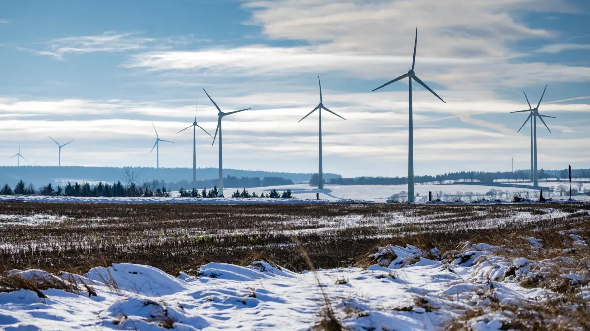 Frostiges Wetter in Nordrhein-Westfalen: 23.11.2025, Nordrhein-Westfalen, Hellenthal: Windkraftanlagen stehen auf einem mit Schnee bedecktem Feld. Foto: Thomas Banneyer/dpa +++ dpa-Bildfunk +++