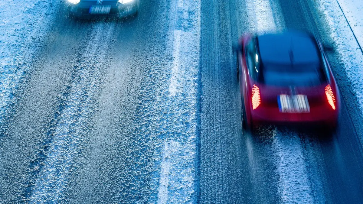Wetter in Bayern - Schnee in Niederbayern: 24.11.2025, Bayern, Straubing: Autos fahren über eine schneebedeckte Straße. Foto: Armin Weigel/dpa +++ dpa-Bildfunk +++