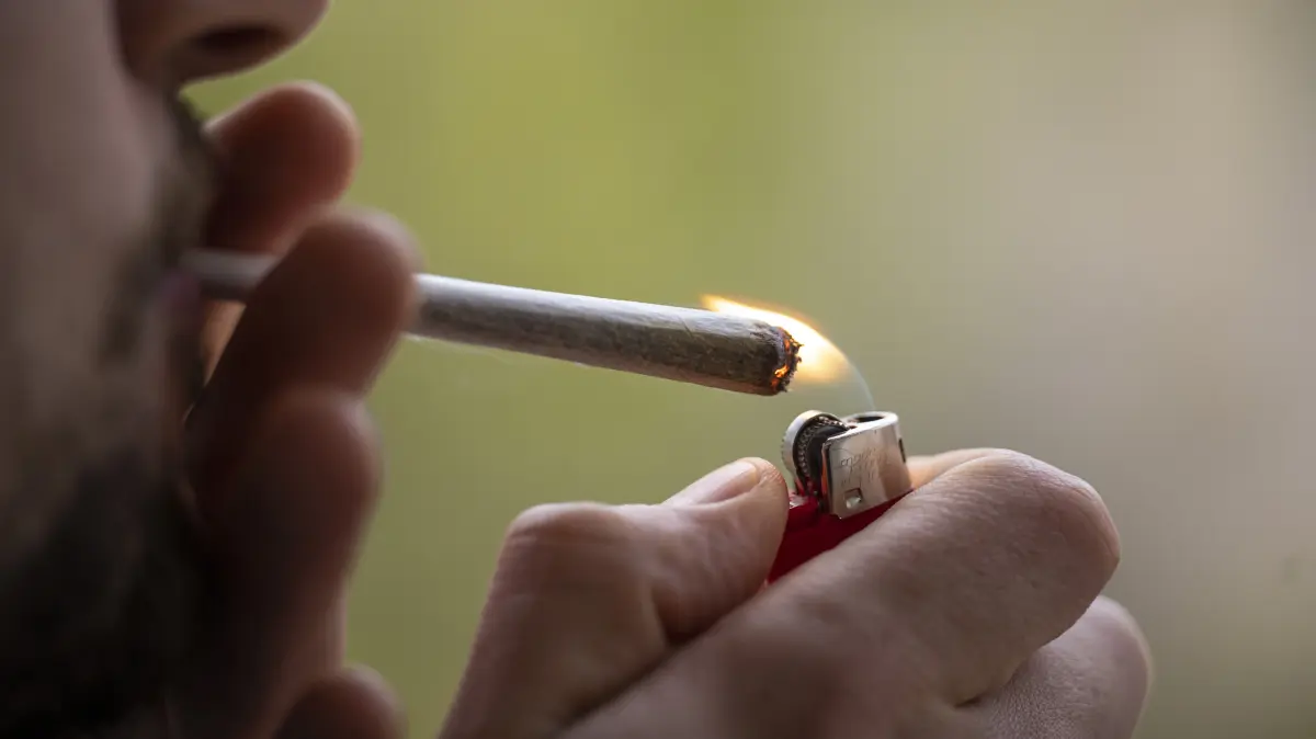 Ein Mann zündet sich einen Joint an. Ein versuchter Schmuggel von gut elf Gramm Haschisch in die JVA Rottenburg ist ein Streitpunkt vor Gericht. (Symbolfoto) Foto: Hannes P Albert/dpa