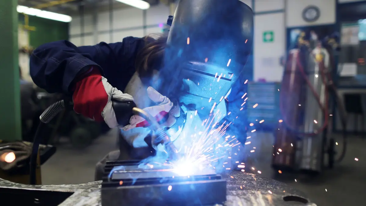 Eine Auszubildende zum Schweißer arbeitet einem Stück Metall: ARCHIV - Ein Freiwilliges Handwerksjahr unterscheidet sich deutlich von einem Freiwilligen Sozialen Jahr mit Fokus auf handwerkliche Tätigkeiten. (zu dpa: «Freiwilliges Handwerksjahr unterscheidet sich vom FSJ») Foto: Oliver Berg/dpa/dpa-mag - Honorarfrei nur für Bezieher des Dienstes dpa-Magazin +++ dpa-Magazin +++
