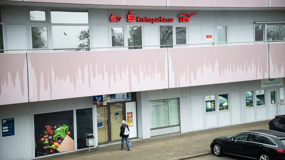 Bankfiliale WHO, eine Frau steht vor der verschlossenen Volksbank-Filiale, darüber die Kreissparkasse.