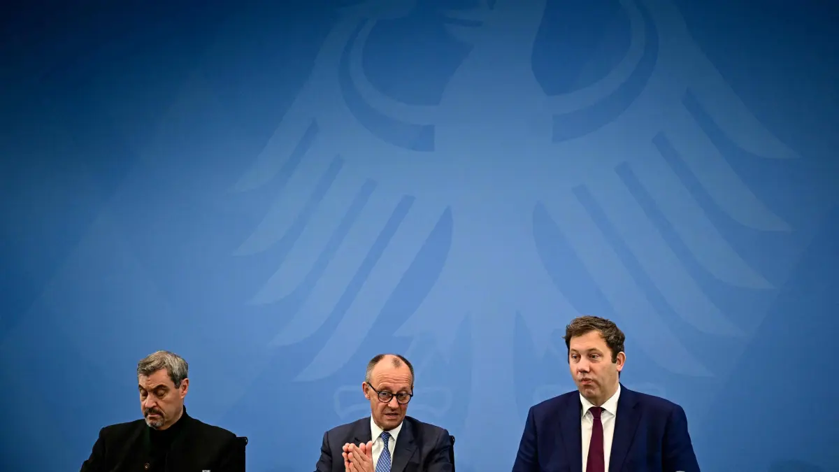 (L-R) Bavaria's State Premier and leader of the conservative Christian Social Union (CSU) Markus Soeder, German Chancellor Friedrich Merz and German Finance Minister, Vice-Chancellor and leader of the Germany's Social Democratic Party (SPD) Lars Klingbeil attend a press briefing on the results of the coalition committee consultations on the pensions package, on November 28, 2025 at the Chancellery in Berlin. (Photo by Tobias SCHWARZ / AFP)