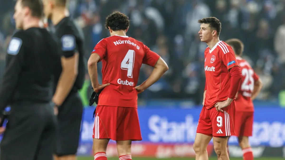 1. FC Magdeburg - 1. FC Nürnberg: 29.11.2025, Sachsen-Anhalt, Magdeburg: Fußball: 2. Bundesliga, 1. FC Magdeburg - 1. FC Nürnberg, 14. Spieltag, Avnet Arena. Fabio Gruber (1. FC Nürnberg) und Semir Telalovic (r, 1. FC Nürnberg) reagieren auf die Niederlage. Foto: Andreas Gora/dpa - WICHTIGER HINWEIS: Gemäß den Vorgaben der DFL Deutsche Fußball Liga bzw. des DFB Deutscher Fußball-Bund ist es untersagt, in dem Stadion und/oder vom Spiel angefertigte Fotoaufnahmen in Form von Sequenzbildern und/oder videoähnlichen Fotostrecken zu verwerten bzw. verwerten zu lassen. +++ dpa-Bildfunk +++