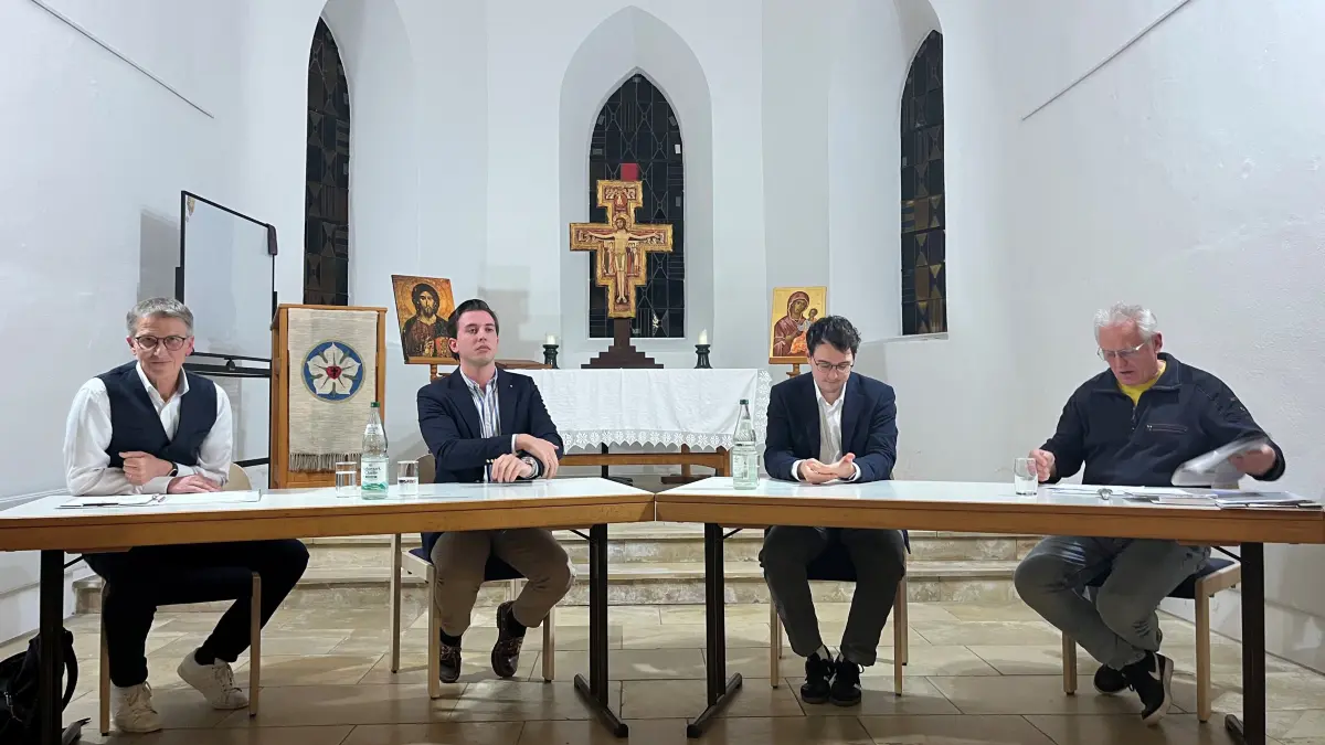 Sakrales Podium: Volker Ludwig vom Aktionsbündnis, Mulfingens Bürgermeister Sören Döffinger (CDU), der Öhringer Stadtrat Mario Dietel (Bündnis 90 / Die Grünen) und Moderator Daniel Febel auf dem Diskussionsabend.