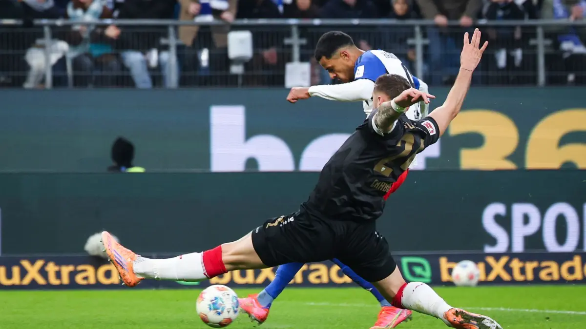 Hamburger SV - VfB Stuttgart: 30.11.2025, Hamburg: Fußball: Bundesliga, Hamburger SV - VfB Stuttgart, 12. Spieltag, Volksparkstadion, Robert Glatzel (Hamburger SV) trifft zum 1:0 gegen Jeff Chabot (VfB Stuttgart). Foto: Christian Charisius/dpa - WICHTIGER HINWEIS: Gemäß den Vorgaben der DFL Deutsche Fußball Liga bzw. des DFB Deutscher Fußball-Bund ist es untersagt, in dem Stadion und/oder vom Spiel angefertigte Fotoaufnahmen in Form von Sequenzbildern und/oder videoähnlichen Fotostrecken zu verwerten bzw. verwerten zu lassen. +++ dpa-Bildfunk +++