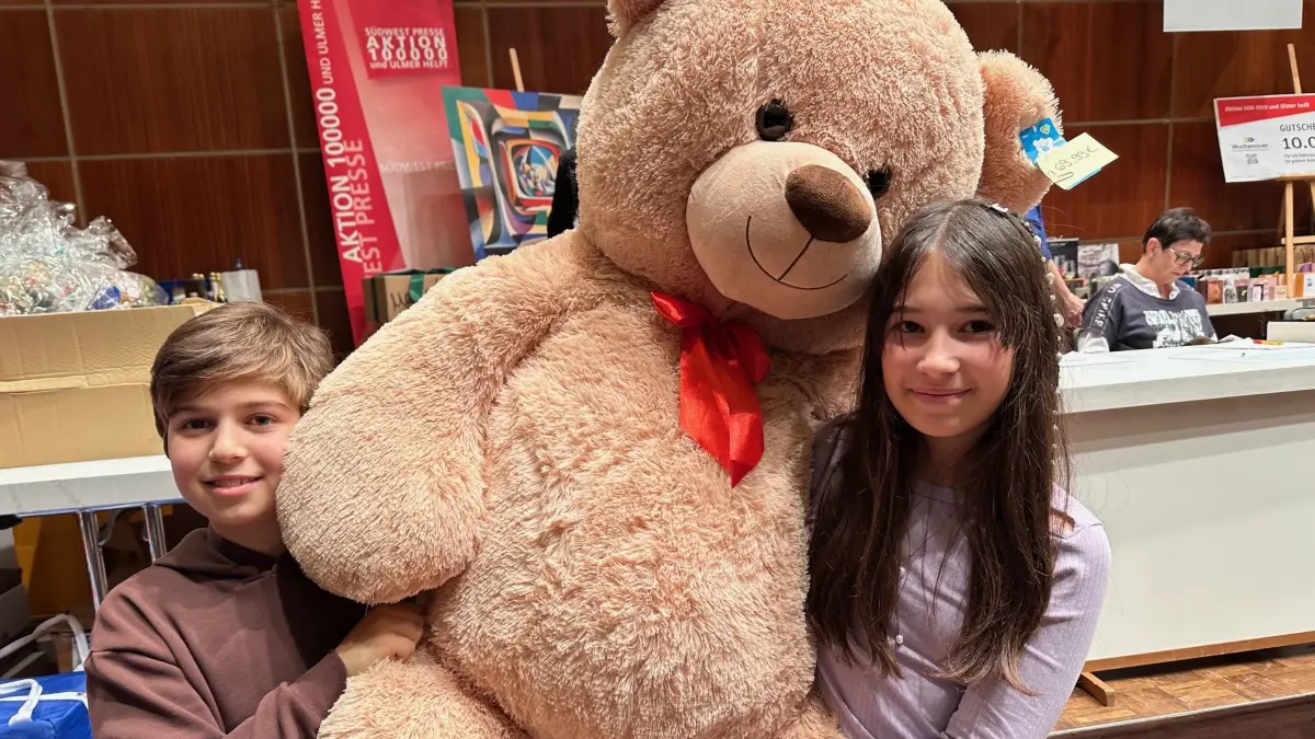 Yunus und Jade mit Teddybär bei der Versteigerung.