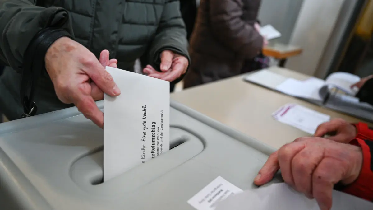 Eine Frau steckt in der Schlosskirche am Ufer des Bodensees bei der Kirchenwahl der Evangelischen Landeskirche ihren Stimmzettelumschlag in die Wahlurne. +++ dpa-Bildfunk +++