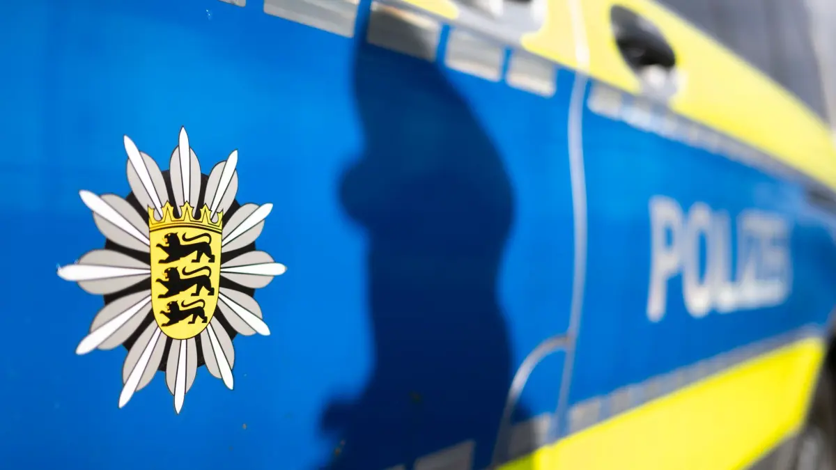 Polizei Baden-Württemberg: ILLUSTRATION - 20.11.2025, Baden-Württemberg, Stuttgart: Der Schatten einer Polizistin der Polizei Baden-Württemberg zeichnet sich an der Tür eines Polizeifahrzeugs ab. (gestellte Szene) (zu dpa: «Einbrecher stehlen 300 Kilogramm Speisefett von Raststätte») Foto: Marijan Murat/dpa +++ dpa-Bildfunk +++