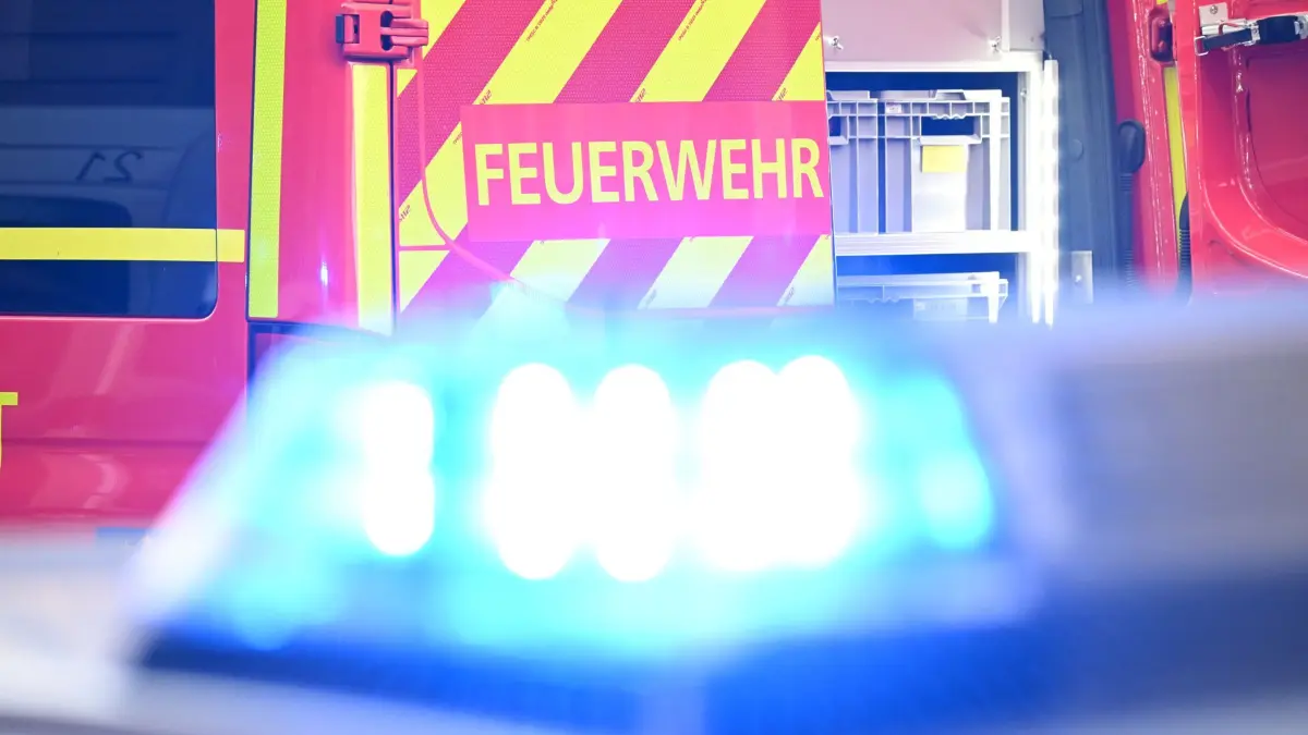 ARCHIV - 02.05.2025, Baden-Württemberg, Stuttgart: Ein Fahrzeug der Feuerwehr steht bei einem Einsatz auf einer Straße, während im Vordergrund das Blaulicht eines Polizeifahrzeugs zu sehen ist. (zu dpa: «Drei Verletzte nach Brand - Ursache vermutlich in der Küche») Foto: Bernd Weißbrod/dpa +++ dpa-Bildfunk +++