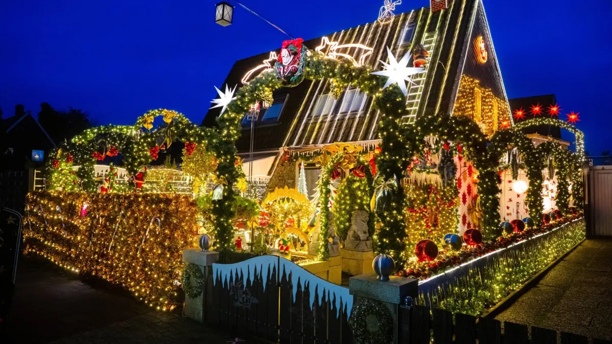 Delmenhorster Weihnachtshaus: PRODUKTION - 28.11.2025, Niedersachsen, Delmenhorst: Das überregional bekannte Weihnachtshaus in Delmenhorst erstrahlt wieder. Nach einem Jahr Pause macht Sven Borchart am ersten Adventssonntag die rund 60 000 Lichter an seinem geschmückten Haus und Grundstück wieder an. In diesem Jahr haben die Lichter für Borchart eine ganz besondere Bedeutung: Er schaltet sie bis zum 6. Januar jeden Abend in Gedenken an seine verstorbene Frau Martina an. (zu dpa: «Delmenhorster Weihnachtshaus erstrahlt wieder») Foto: Sina Schuldt/dpa +++ dpa-Bildfunk +++