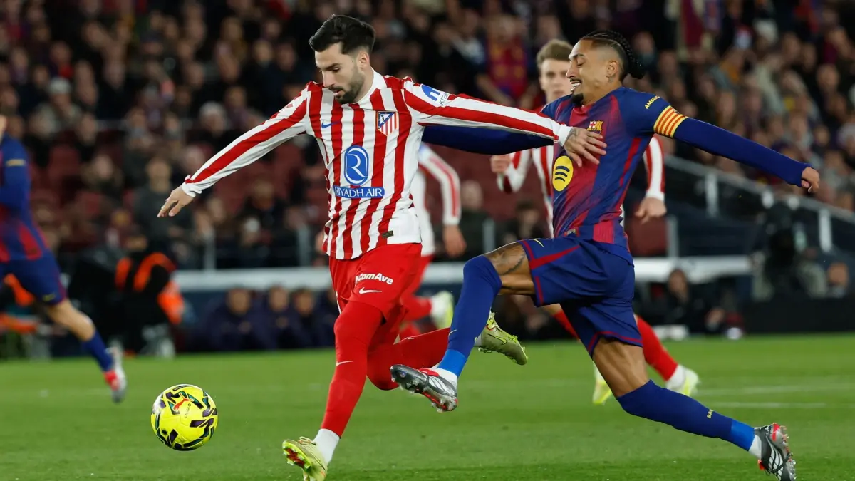 FC Barcelona - Atlético Madrid: 02.12.2025, Spanien, Barcelona: Fußball: Primera División, Spanien, FC Barcelona - Atlético Madrid, 19. Spieltag. Barcelonas Raphinha (r) und Atletico Madrids Alex Baena kämpfen um den Ball. Foto: Joan Monfort/AP/dpa +++ dpa-Bildfunk +++