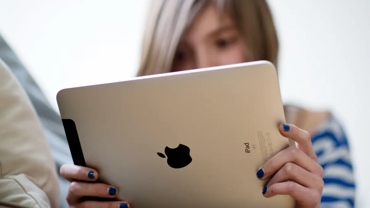 Ein Mädchen hält ein Tablet.