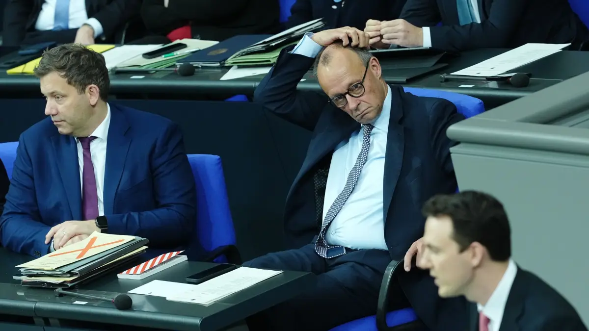 Bundestag - Rentenpaket: 05.12.2025, Berlin: Pascal Reddig (CDU, r), Vorsitzender der Jungen Gruppe der Union im Bundestag, spricht in der Sitzung des Bundestags, im Hintergrund sitzen Lars Klingbeil (SPD, l), Bundesminister der Finanzen, und Bundeskanzler Friedrich Merz (CDU). Thema ist die Rentenreform. Foto: Kay Nietfeld/dpa +++ dpa-Bildfunk +++