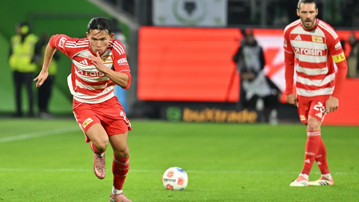 VfL Wolfsburg - 1. FC Union Berlin: 06.12.2025, Niedersachsen, Wolfsburg: Fußball: Bundesliga, VfL Wolfsburg - 1. FC Union Berlin, 13. Spieltag, Volkswagen Arena. Christopher Trimmel (1. FC Union Berlin) steht bei einem Freistoß, während Woo-yeong Jeong (1. FC Union Berlin) über das Feld sprintet. Foto: Swen Pförtner/dpa - WICHTIGER HINWEIS: Gemäß den Vorgaben der DFL Deutsche Fußball Liga bzw. des DFB Deutscher Fußball-Bund ist es untersagt, in dem Stadion und/oder vom Spiel angefertigte Fotoaufnahmen in Form von Sequenzbildern und/oder videoähnlichen Fotostrecken zu verwerten bzw. verwerten zu lassen. +++ dpa-Bildfunk +++
