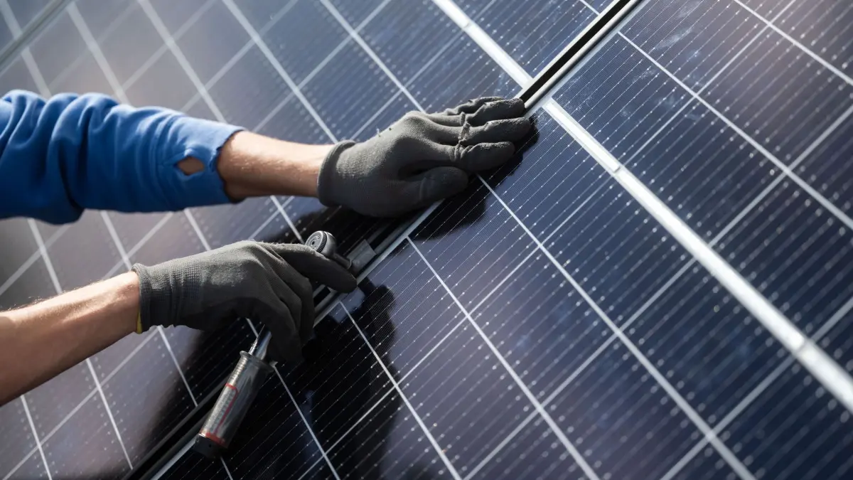 PV-Anlage: ARCHIV - 13.10.2021, Baden-Württemberg, Stuttgart: Ein Mann montiert Photovoltaikmodule auf dem Dach eines Hauses. (zu dpa: «Bremen investiert in Turnhallen, Radwege und Häfen») Foto: Marijan Murat/dpa +++ dpa-Bildfunk +++