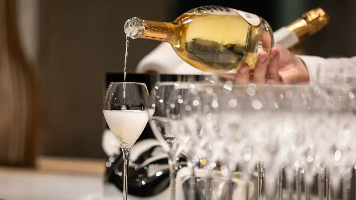 Kellner schenkt ein Glas Champagner ein
