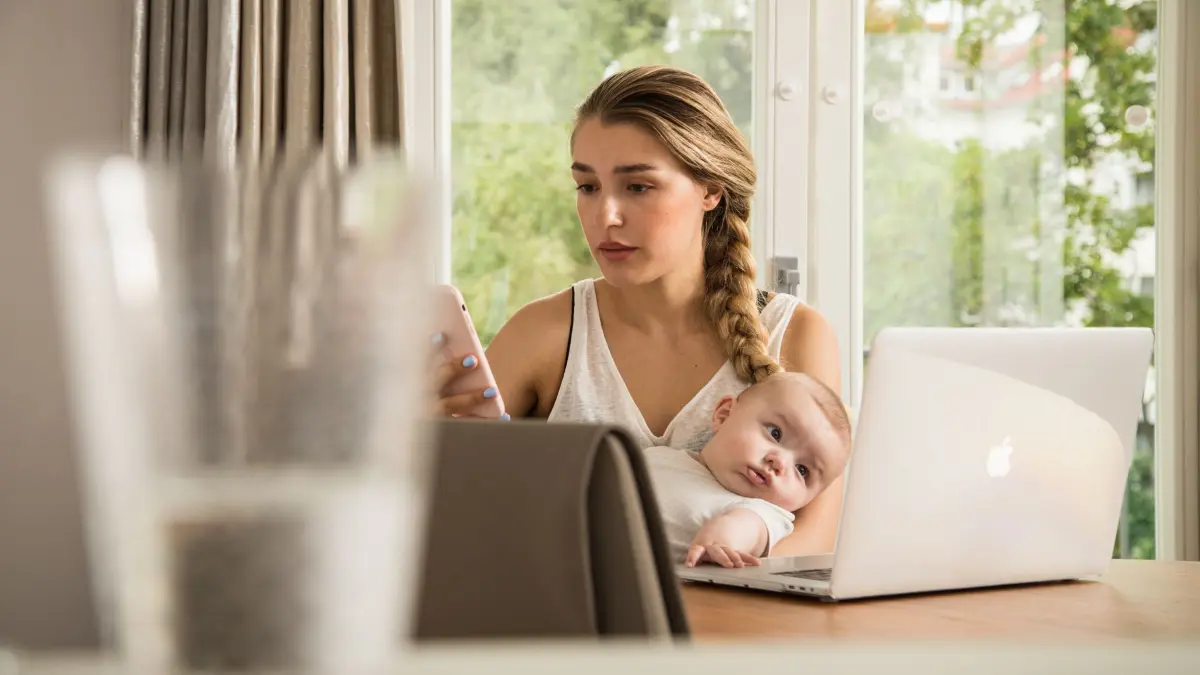 Eine Frau sitzt mit ihrem Baby am Computer: ILLUSTRATION - Alles verstanden? Einen Elterngeldantrag zu stellen ist nicht ganz trivial. (zu dpa: «So wählen Eltern das richtige Elterngeld-Modell») Foto: Christin Klose/dpa-tmn - Honorarfrei nur für Bezieher des dpa-Themendienstes +++ dpa-Themendienst +++