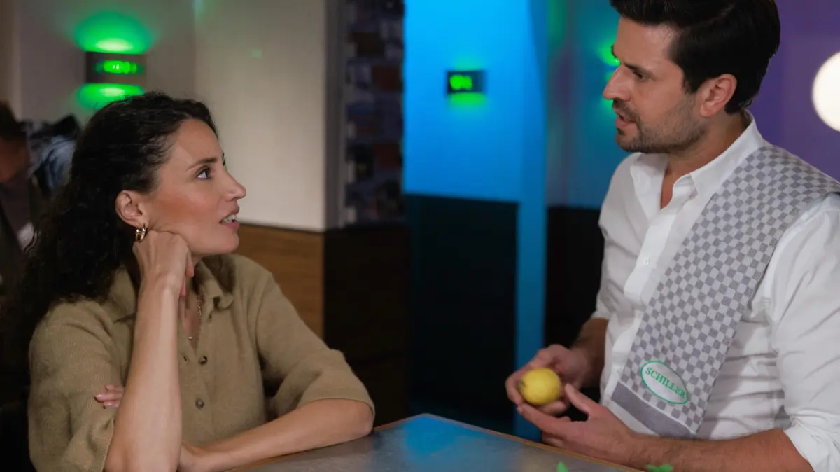 Naomi (Nadine Menz) will herausfinden, was es mit Brittas "Redeverbot" auf sich hat. Rechts Paco (Milos Vukovic)