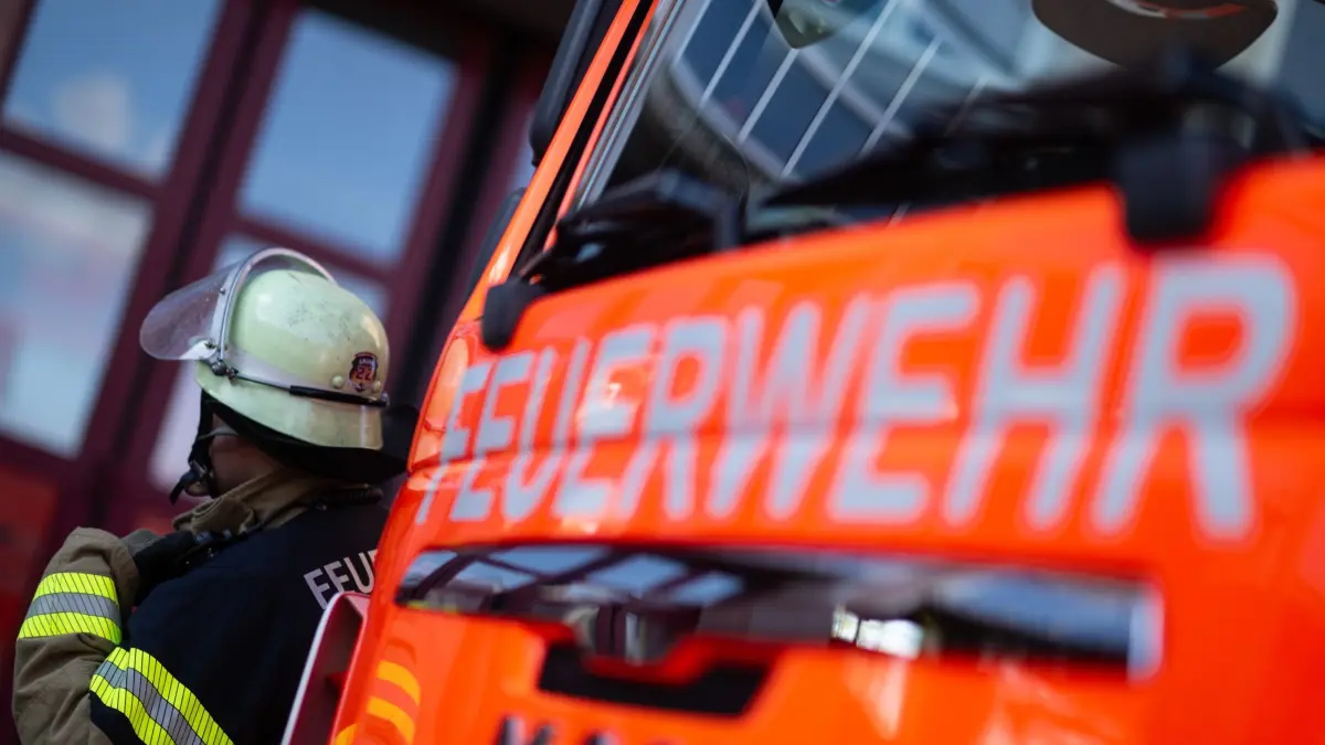 Feuerwehrmann steht neben einem Feuerwehrauto
