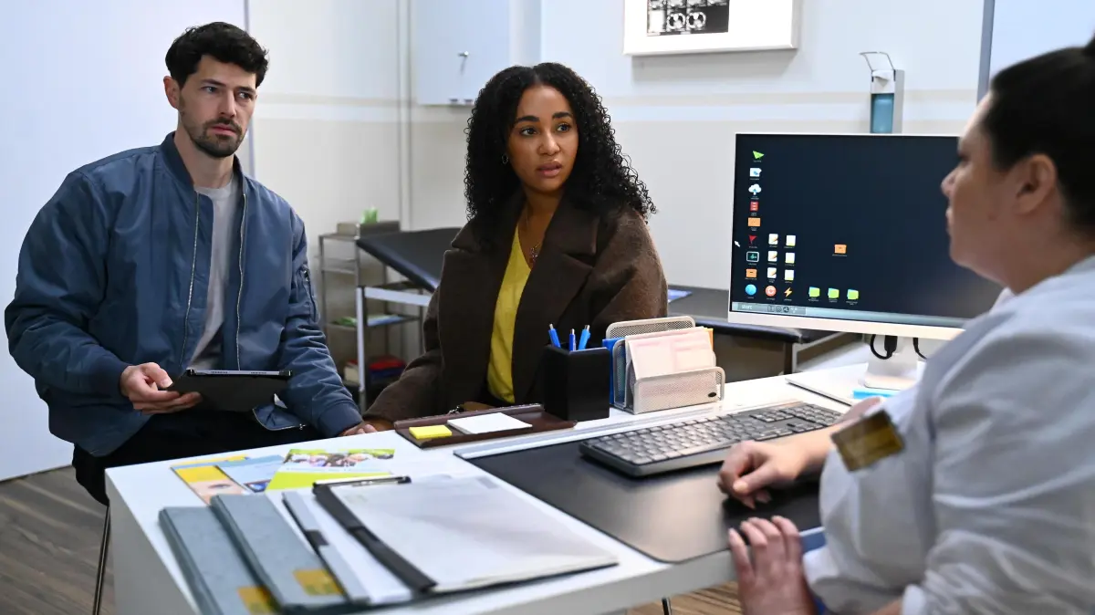 Jan (Daniel Noah) und Imani (Féréba Koné) sind fassungslos, als Vanessa (Julia Augustin) das Ergebnis der Untersuchung mitteilt.