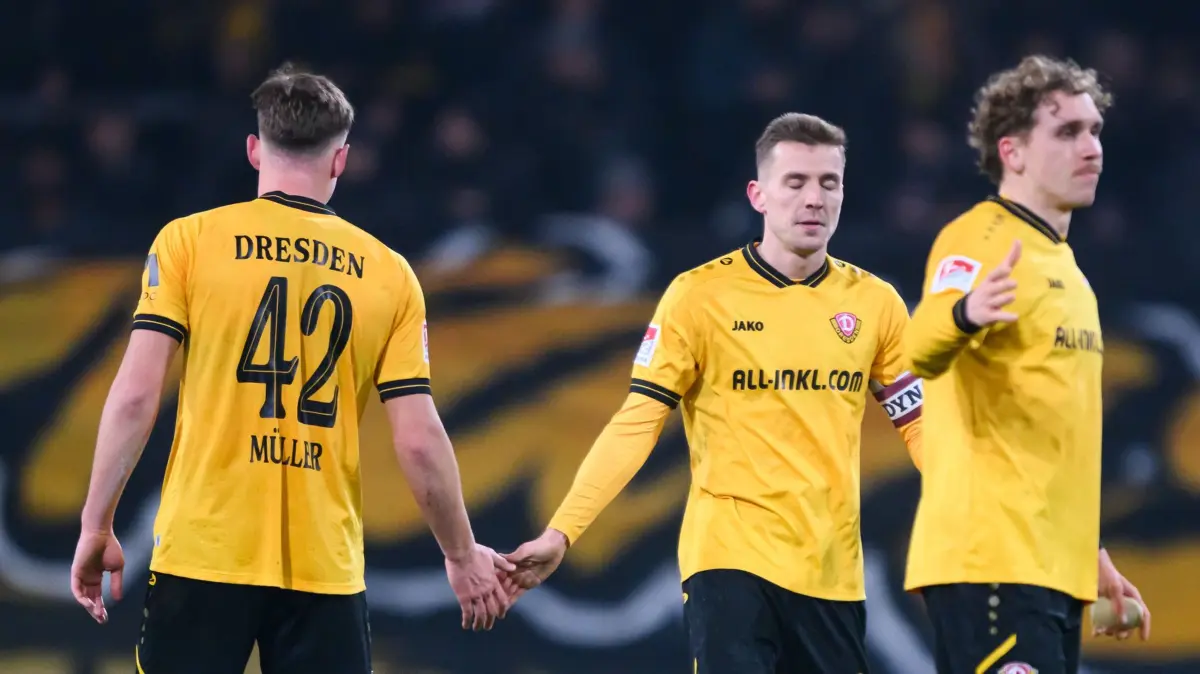 SG Dynamo Dresden - Eintracht Braunschweig: 12.12.2025, Sachsen, Dresden: Fußball: 2. Bundesliga, SG Dynamo Dresden - Eintracht Braunschweig, 16. Spieltag, Rudolf-Harbig-Stadion, Friedrich Müller (Dynamo Dresden, l-r), Niklas Hauptmann (Dynamo Dresden) und Luca Herrmann (Dynamo Dresden) stehen nach der Niederlage auf dem Feld. Foto: Robert Michael/dpa - WICHTIGER HINWEIS: Gemäß den Vorgaben der DFL Deutsche Fußball Liga bzw. des DFB Deutscher Fußball-Bund ist es untersagt, in dem Stadion und/oder vom Spiel angefertigte Fotoaufnahmen in Form von Sequenzbildern und/oder videoähnlichen Fotostrecken zu verwerten bzw. verwerten zu lassen. +++ dpa-Bildfunk +++