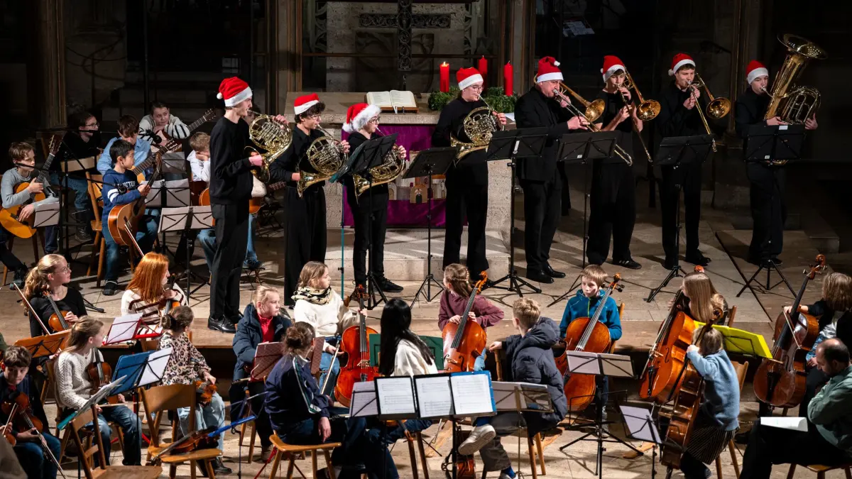 Weihnachtskonzert der Tübinger Musikschule in der Stiftskirche: Während die Horn- und Posaunenklasse begleitet von Schlagwerk spielt, schauen andere Ensembles gespannt zu.